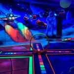 Glow in the dark midgetgolf Space thema met neonverlichting en superhelden decoratie bij Van der Ende