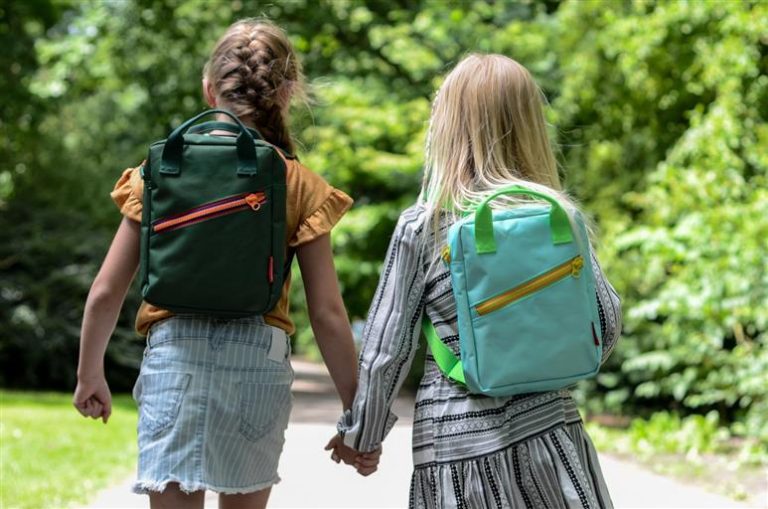 Kind leren fietsen met helm en ouderlijke begeleiding in veilige omgeving