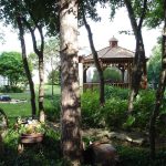 Moderne overkapping trend in tuin met comfortabele zithoek en groene planten