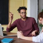 Twee collega's in gesprek met mediator over arbeidsconflict sneller opgelost in veilige omgeving